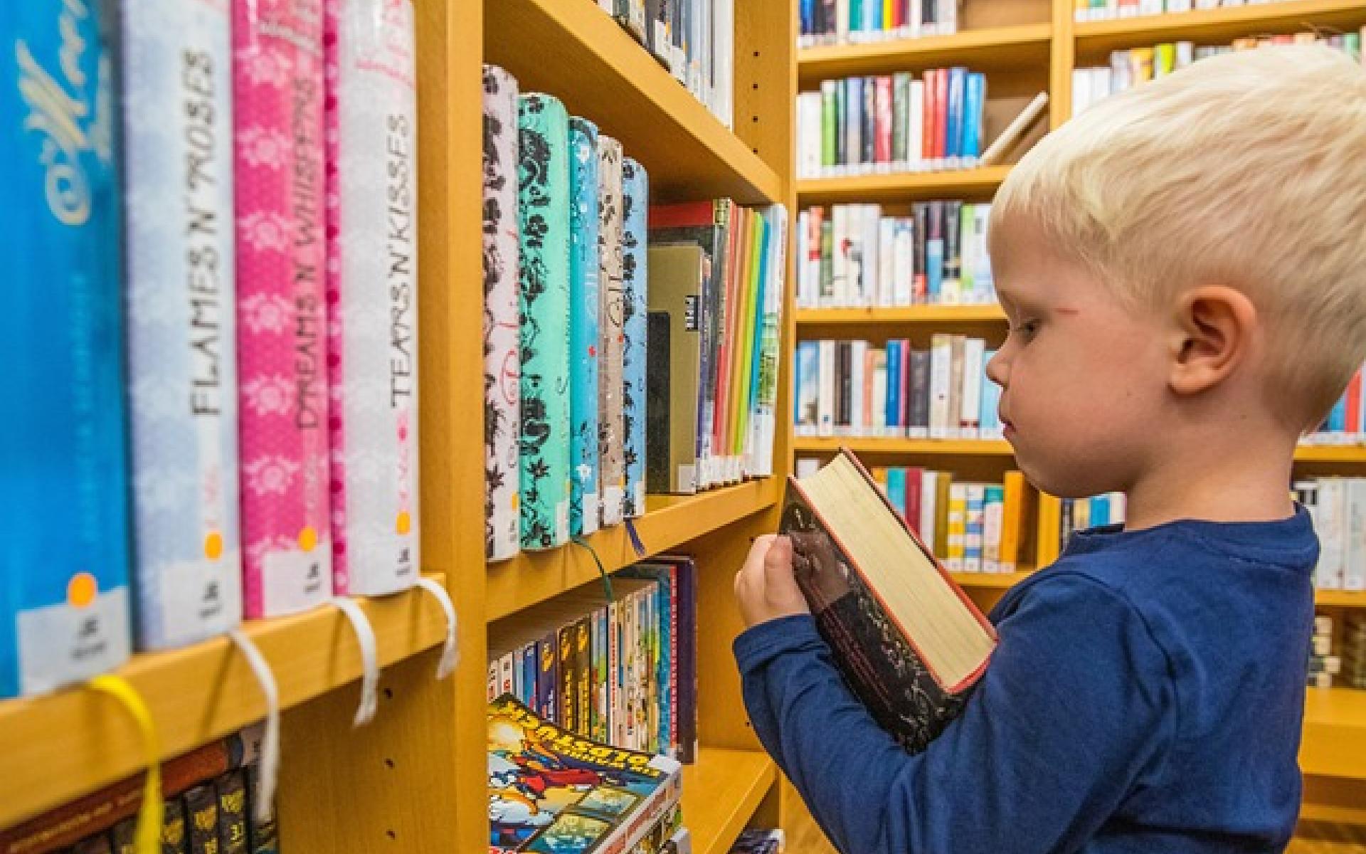 Kind vor Bücherregal